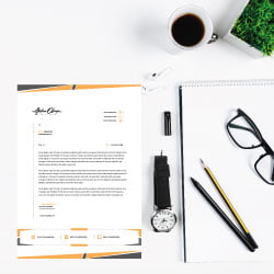 Schreibtisch mit Dokumenten, Stiften und einer Brille