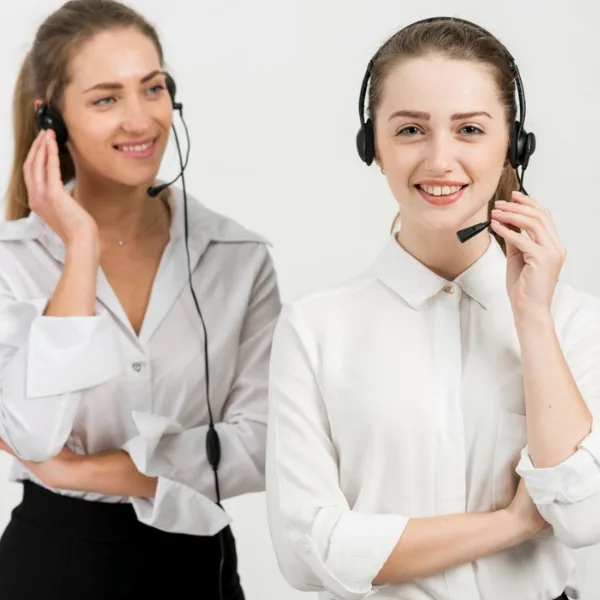 Zwei Kundendienstmitarbeiterinnen mit Headsets, lächelnd