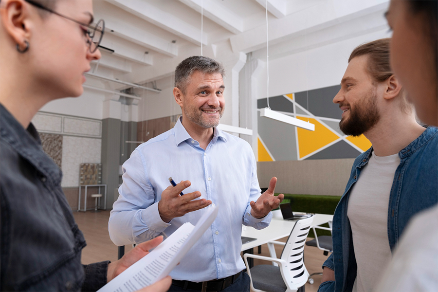 Business-Coach gibt neue Führungskräften wertvolle Tipps zur Teamführung und Konfliktlösung in einem modernen Büro.